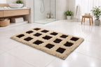 Beige and black Milan block pattern micro polyester bathmat on a modern bathroom floor.