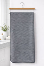 Charcoal grey Vorre Blush textured microfiber bath towel, lint-free quick-dry bath towel displayed in a modern bathroom.