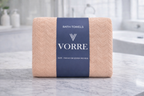 Packaged peach cream Vorre Blush microfiber bath towel folded cleanly with a dark blue luxury packaging wrapper.