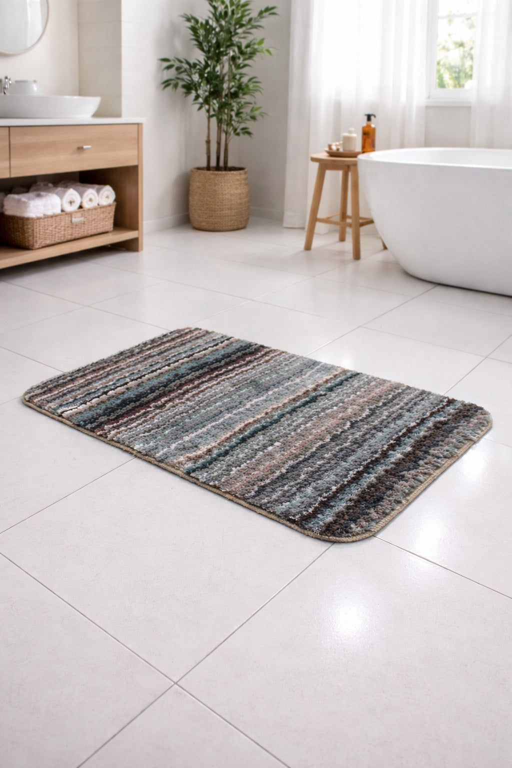 Charcoal grey multi-stripe Vorre Osaka micro polyester bathmat on a modern tiled floor.