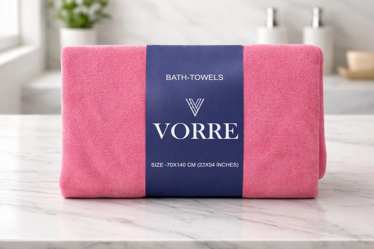 Packaged coral pink Vorre Classic microfiber bath towel wrapped with a signature dark blue belly band displaying the minimalist brand logo.