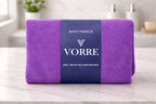 Packaged royal purple Vorre Classic microfiber bath towel neatly folded and wrapped with a dark blue luxury branded paper band.