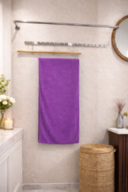 Plush royal purple Vorre Classic microfiber bath towel, premium 400 GSM absorbent body towel displayed in a bright bathroom.