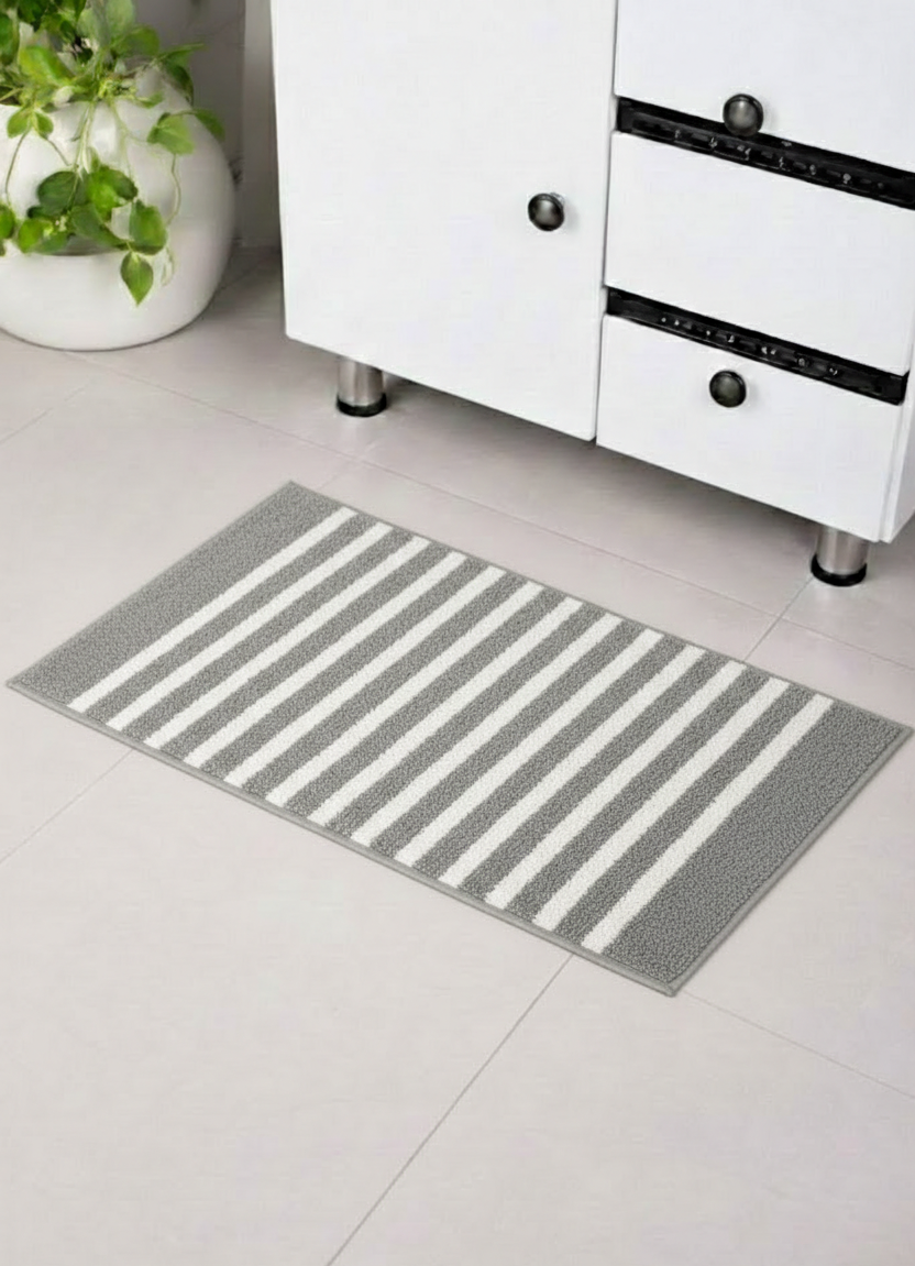 Grey and white horizon stripe micro polyester bathmat on a modern tiled bathroom floor.