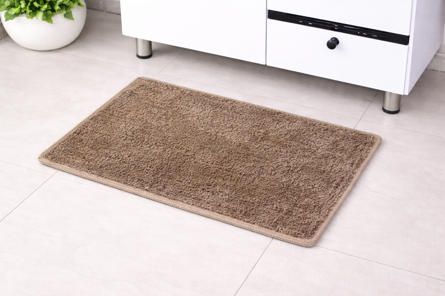 Light brown beige Vorre classic micro polyester bathmat on a modern tiled bathroom floor.