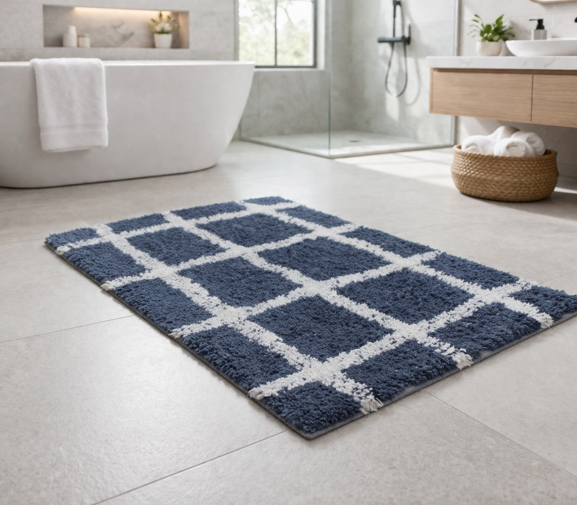 Navy blue checkered grid pattern recycled cotton bathmat set spread out next to a bathtub.