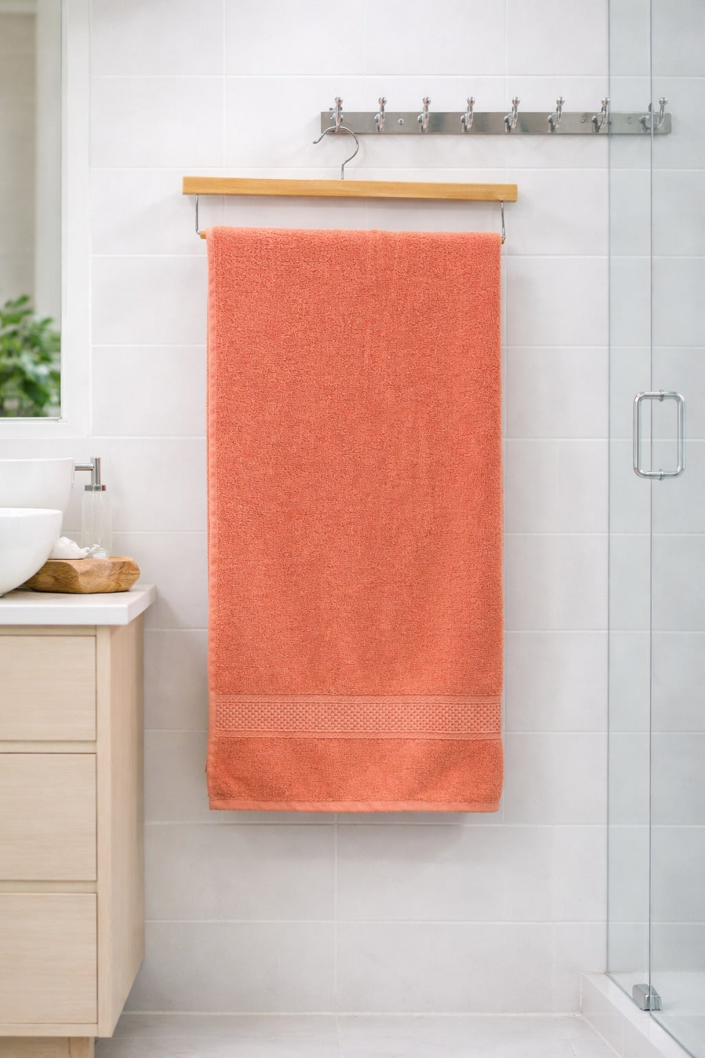 Coral pink Vorre Norvelle recycled cotton bath towel, quick-drying 400 GSM plush terry loop bath towel against a modern bathroom background.