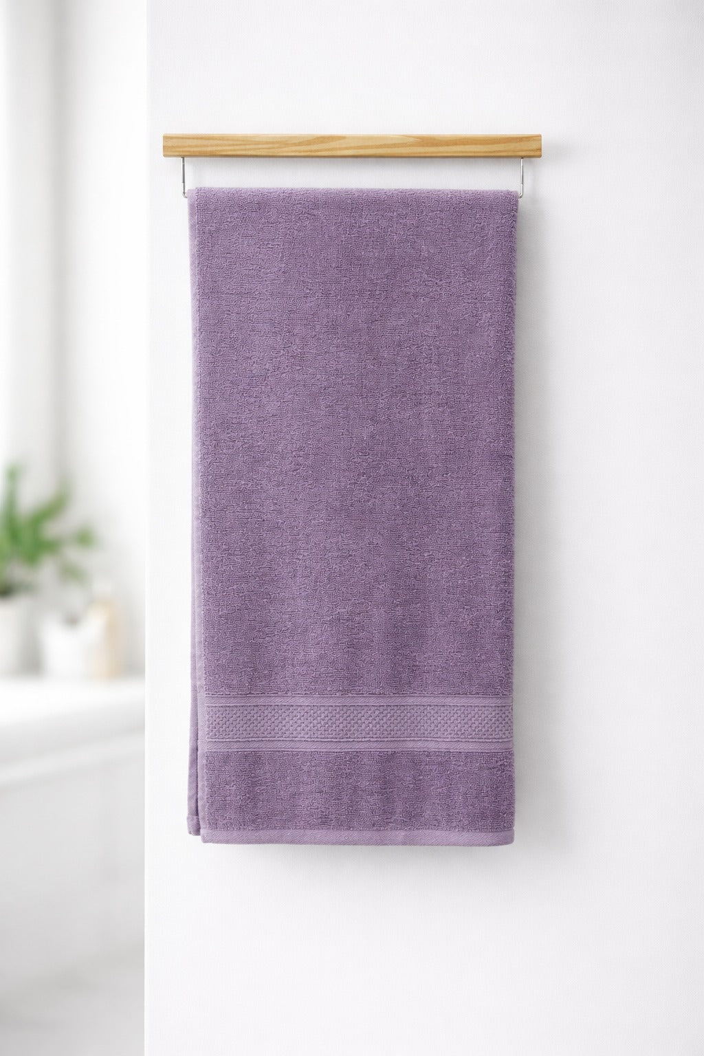 Lavender purple Vorre Norvelle recycled cotton bath towel, 400 GSM terry loop weave towel with elegant dobby border hanging on a bathroom rod.