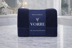 Packaged deep navy blue Vorre Norvelle recycled cotton bath towel featuring a dark blue luxury brand wrapper sleeve.