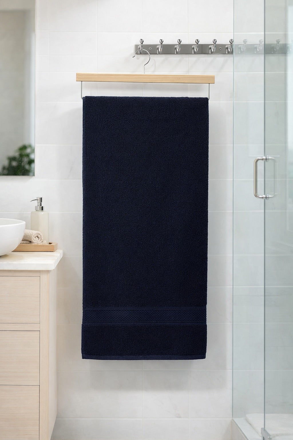 Deep navy blue Vorre Norvelle premium recycled cotton bath towel, soft low-linting 27x54 inches luxury towel hanging neatly.