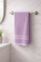 Lavender purple Vorre Norvelle 400 GSM recycled cotton bathroom hand towel hanging over a tub.