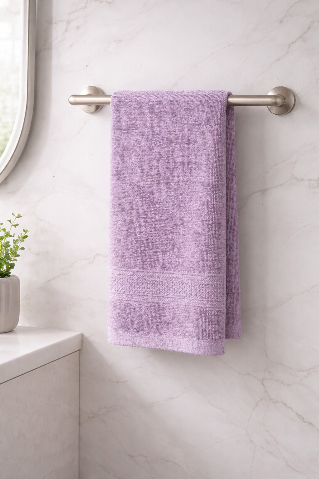 Lavender purple Vorre Norvelle 400 GSM recycled cotton bathroom hand towel hanging over a tub.