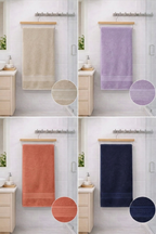 Four assorted colors of Vorre Norvelle recycled cotton bath towels featuring dobby borders hanging on a modern bathroom wooden hanger rack.