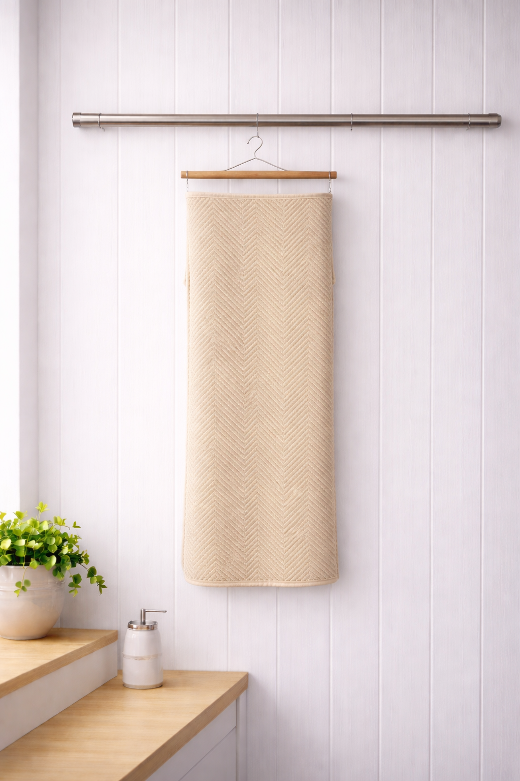 Beige cream textured Vorre Pattern microfiber bath towel, soft lint-free personal care towel hanging on a wooden hanger.
