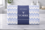 Packaged blue chevron zig-zag Vorre microfiber bath towel showing clean edge details and a premium branded packaging band.