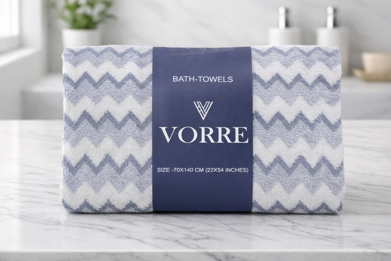 Packaged light grey chevron pattern Vorre microfiber bath towel neatly folded and wrapped with a navy blue luxury brand band.