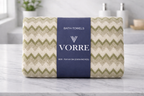 Packaged sage green chevron zig-zag Vorre microfiber bath towel with a dark blue luxury paper product sleeve label.