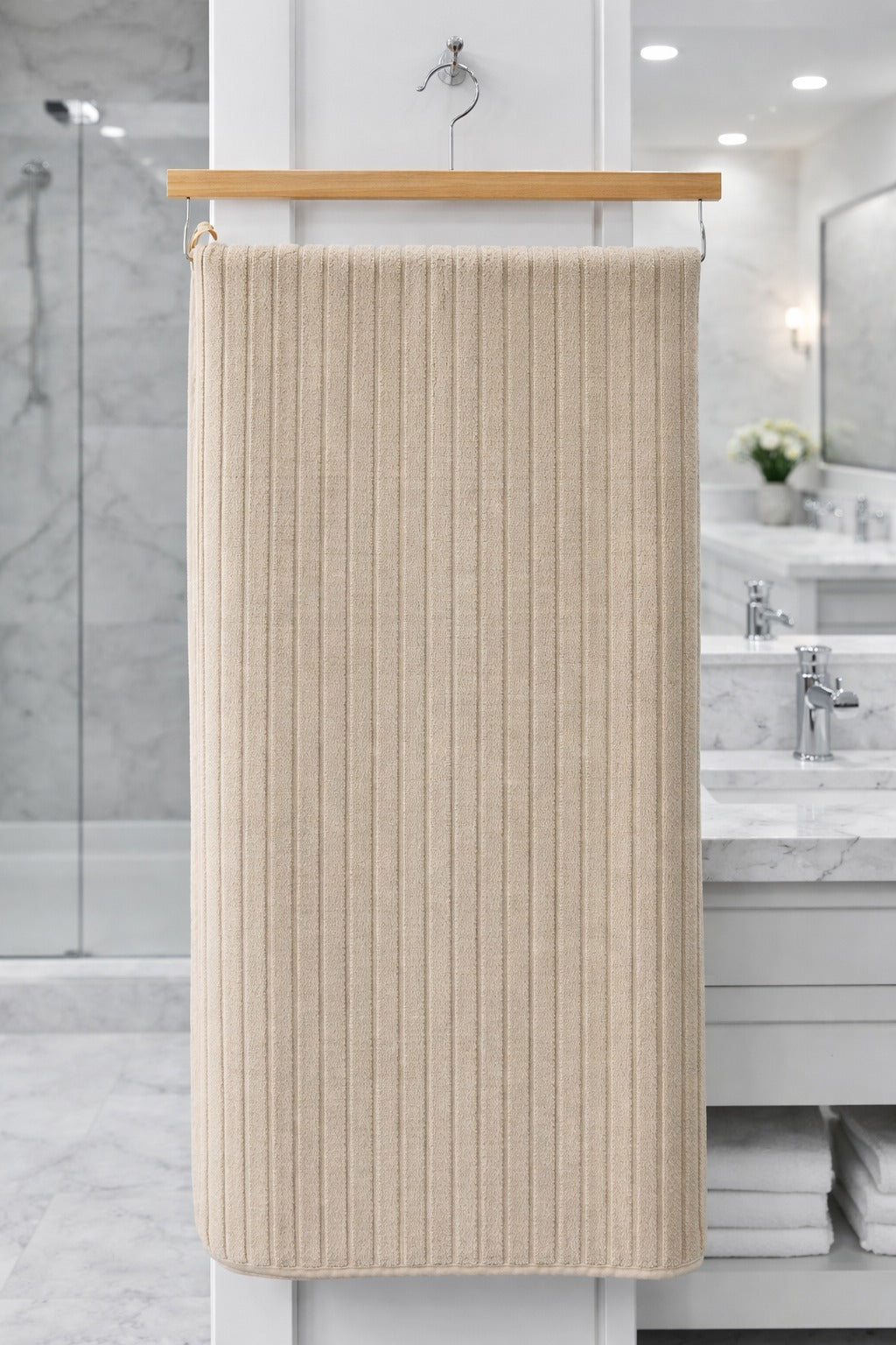 Beige cream textured Vorre Ripped microfiber bath towel, soft lint-free ribbed personal care towel hanging on a wooden hanger.