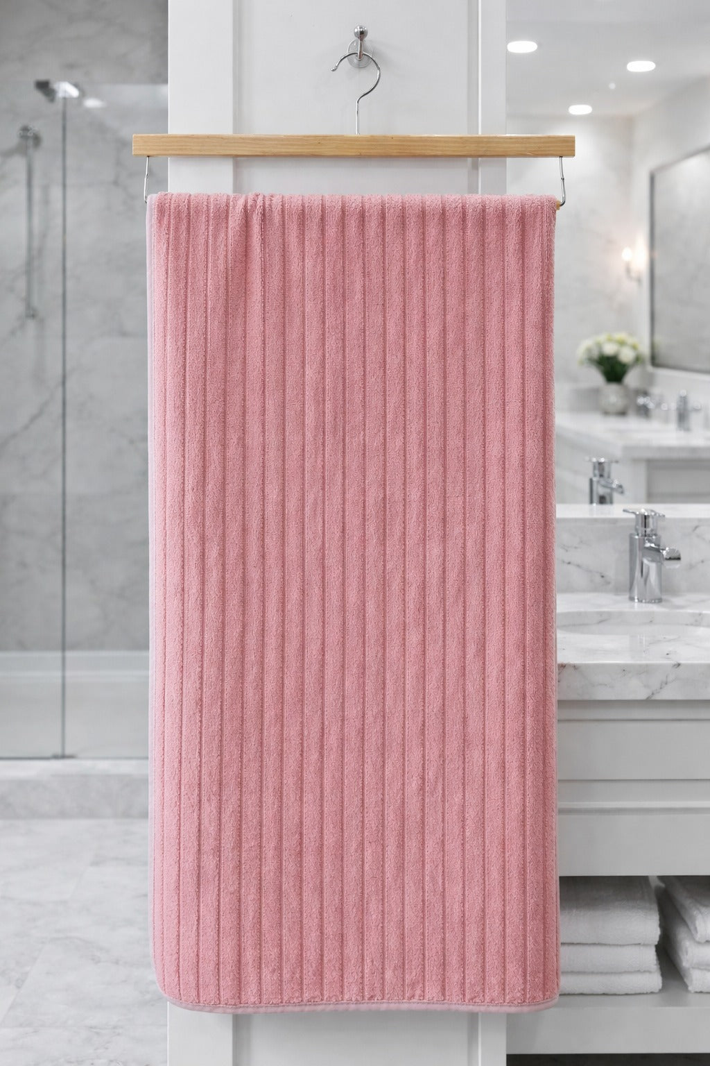 Coral pink vertical ribbed Vorre Ripped microfiber bath towel, highly absorbent everyday utility towel hanging neatly.