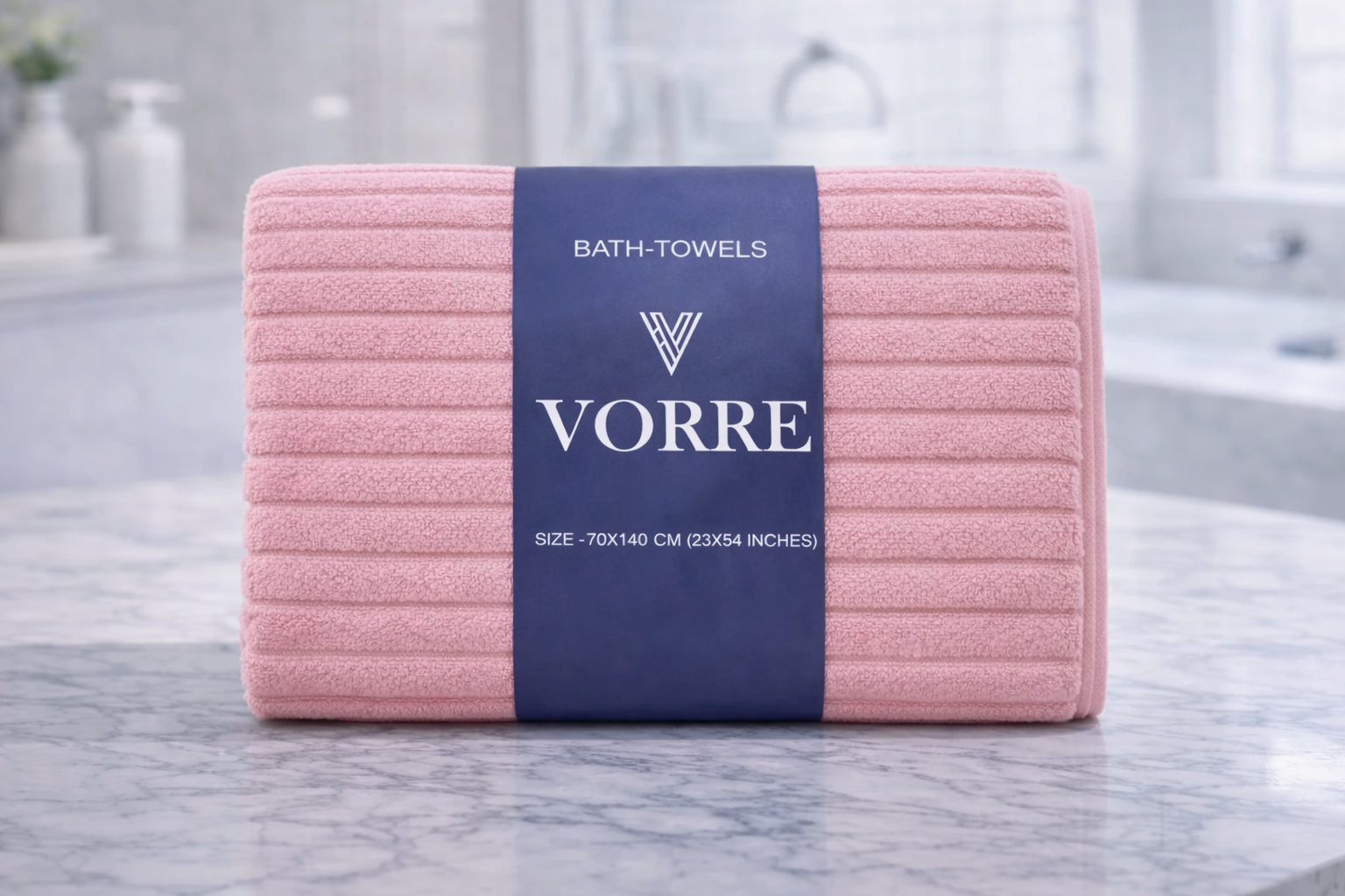 Coral pink vertical ribbed Vorre Ripped microfiber bath towel, highly absorbent everyday utility towel hanging neatly.