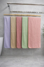 Multi-color display of Vorre Ripped textured microfiber bath towels with vertical ribbed patterns hanging on a wooden towel rack.