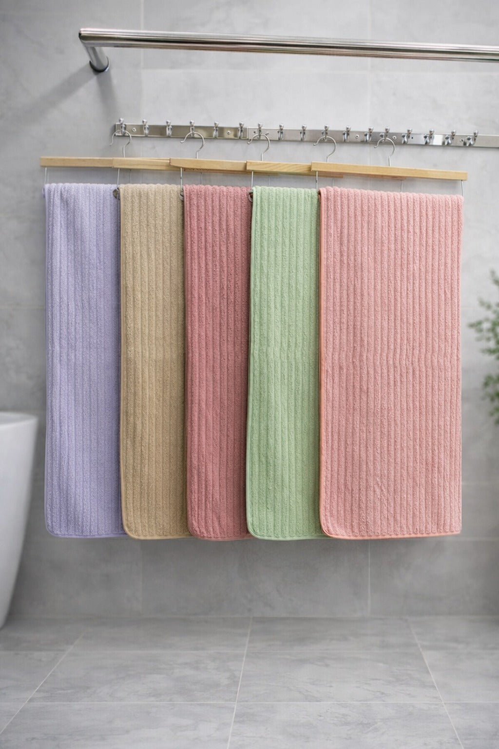 Multi-color display of Vorre Ripped textured microfiber bath towels with vertical ribbed patterns hanging on a wooden towel rack.