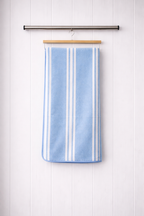 Light blue and white vertical stripe Vorre microfiber bath towel, 280 GSM quick-dry utility towel hanging on a rod.