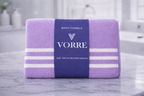 Packaged purple striped Vorre microfiber bath towel, neatly folded with a premium navy product wrapper.