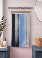 Navy blue, sky blue, and grey striped Vorre TNT micro polyester bath towel, compact absorbent utility towel hanging on a rod.